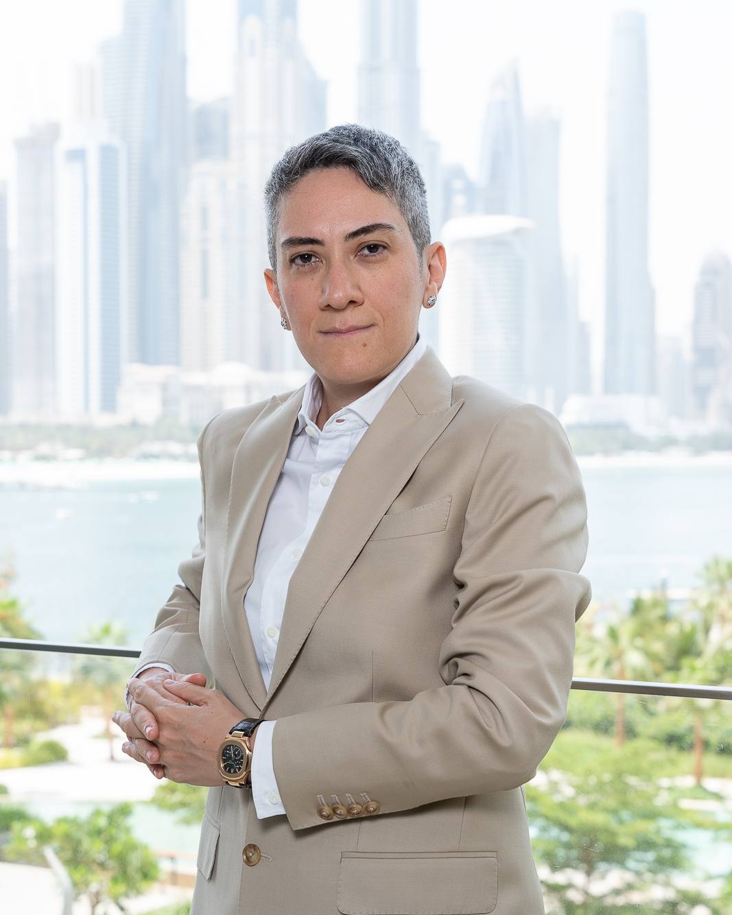 Honey Deylami in a beige suit on a terrace, with the Dubai skyline behind her